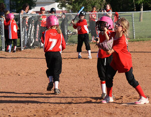 Young Leduc Minor Softball players in bright red uniforms show off the skills they've been taught.