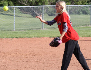 A focused, young Leduc Minor Softball pitcher looks for the strike zone