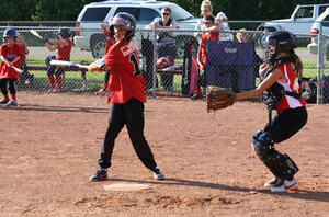 A youth in red baseball uniform gives a mighty swing during a Leduc Minor Softball game